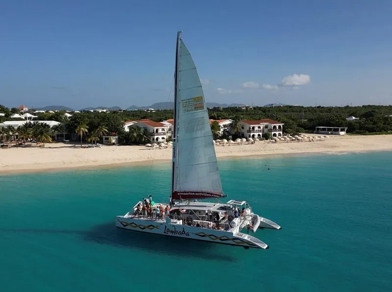 65-foot sailing catamaran on a full-day Sint Maarten boat tour anchored over turquoise reef at the Prickly Pear Cays near Anguilla